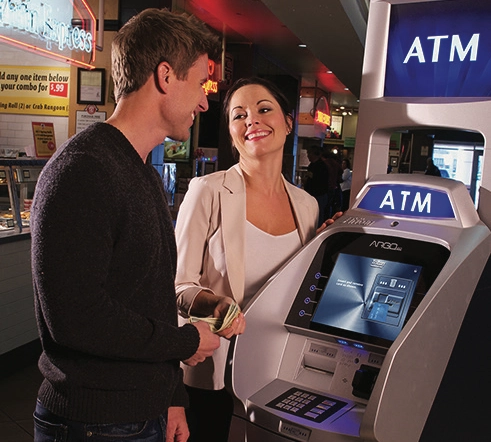 Photo of a couple withdrawing cash from an ATM